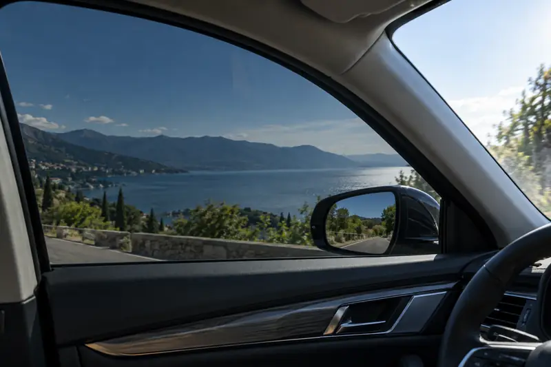Installer squeegeeing nano ceramic window film onto a car side window in a clean bay