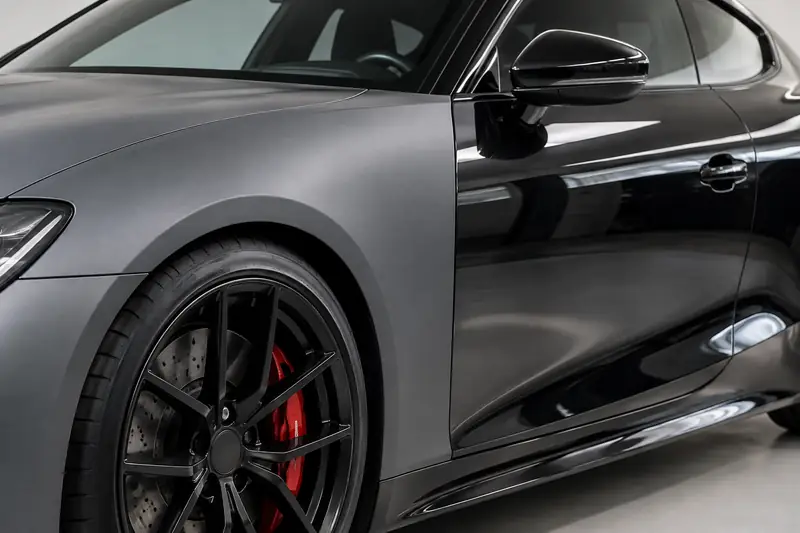 Car hood split between satin black color PPF and matte black vinyl wrap